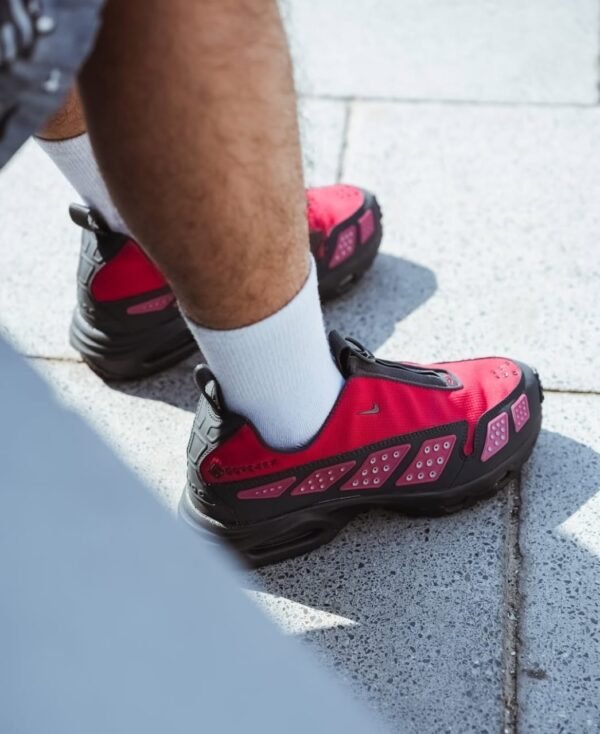 a person wearing red and black first copy shoes